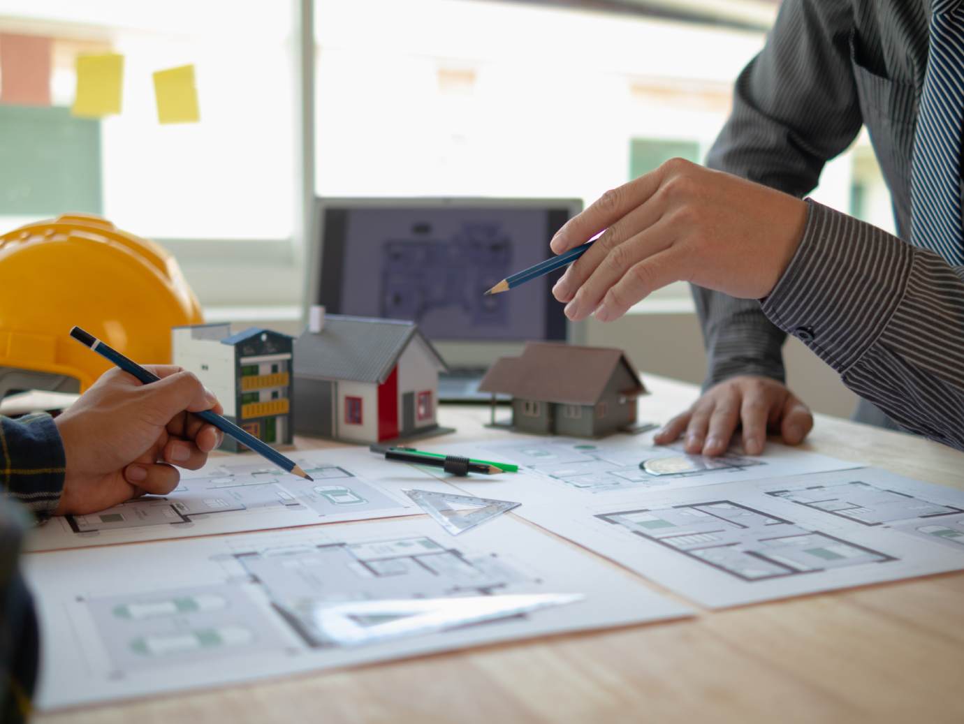 Architects discussing design and construction plans for a greenfield technical facility