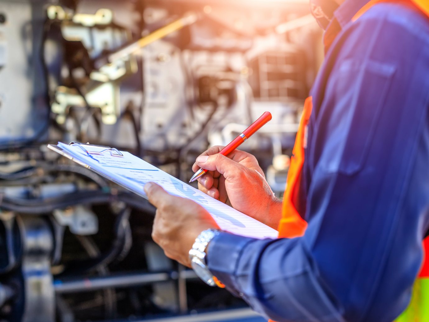 A maintenance worker providing maintenance services standing in front of a machine